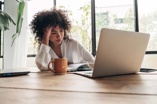 Women staring at laptop looking exhausted