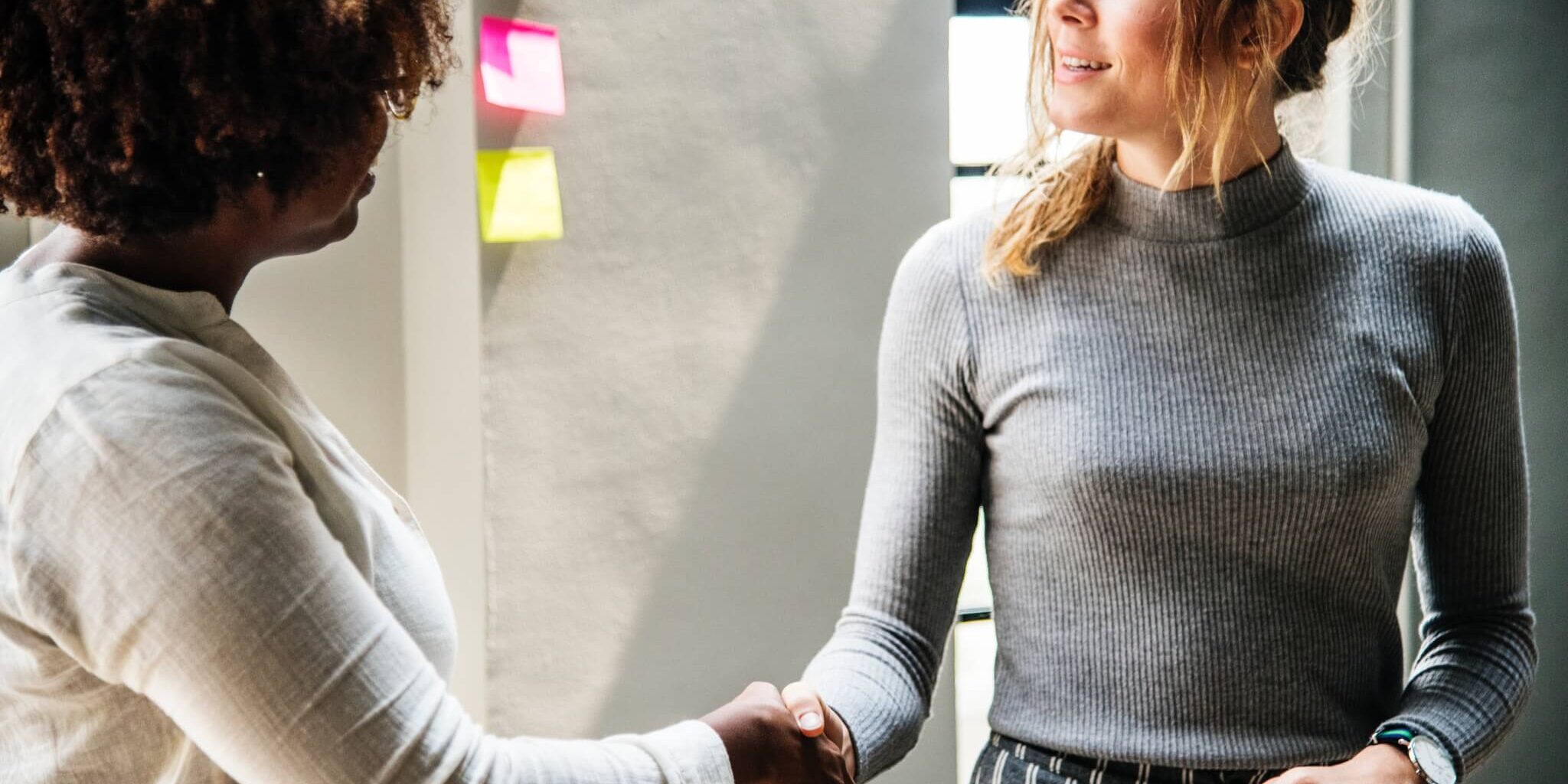 two women shaking hands
