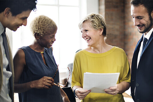 keeping your employment agreements upto date Group of people standing around each other staring at paper