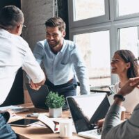 men shaking hands over table