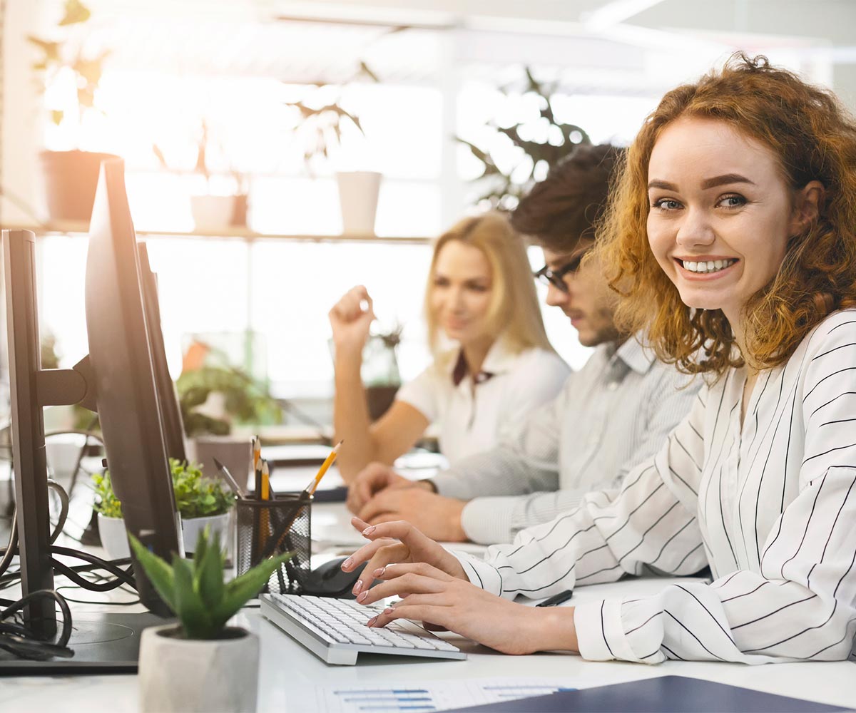 woman sitting at computer smiling at camera