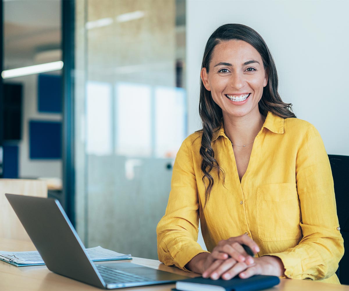 woman sitting at computer smiling at camera